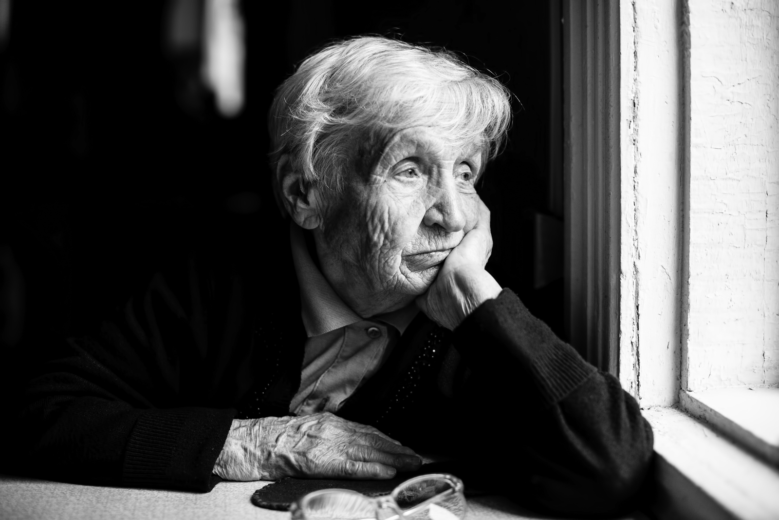 woman looking out window black and white