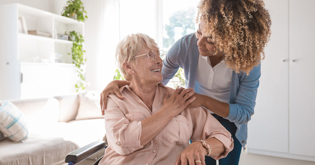 Woman being embraced by another woman in an assisted living environment